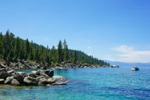 Image of Lake and side of land with rocks and trees. 