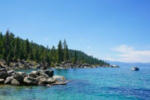 Image of Lake and side of land with rocks and trees. 