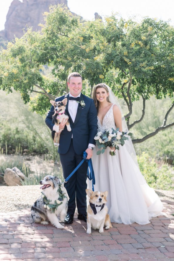 Bride and Groom posing with their three dogs.
