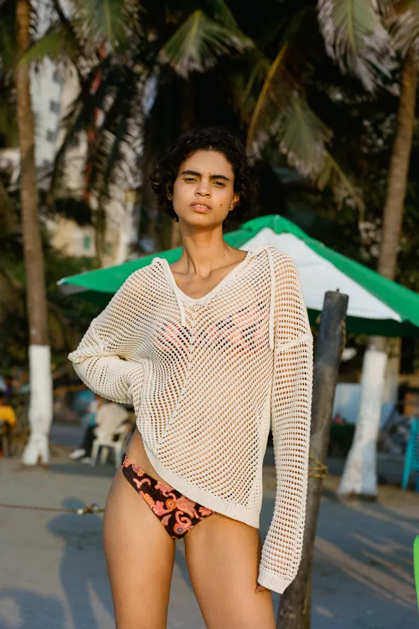 Woman in A.L.C. brand two-piece bathing suite with print and white see-through cover-up.