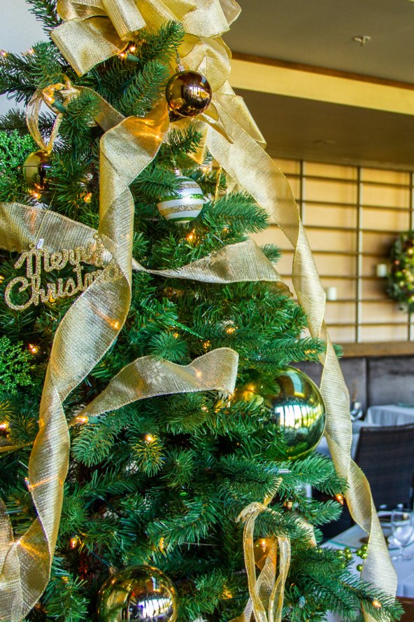 Close-up of Christmas Tree decorated with lights, bulbs and gold tensile in elements. n