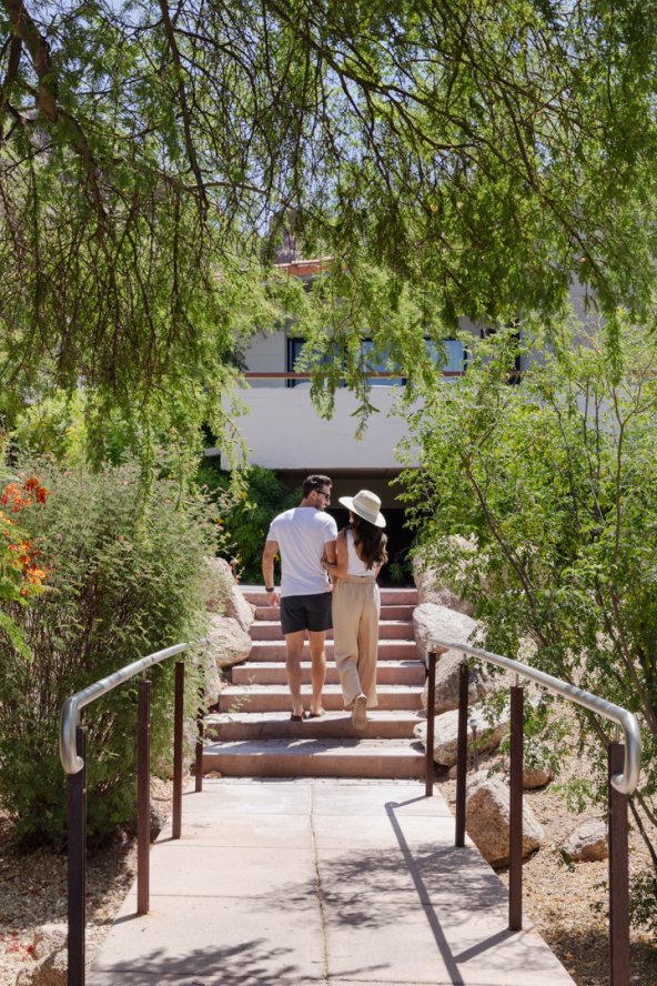 Couple walking through the lush desert landscape outside Sanctuary's Mountain Casitas and Suites.