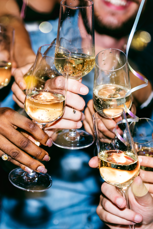 A group of friends brings their Champagne glasses together in a cheers