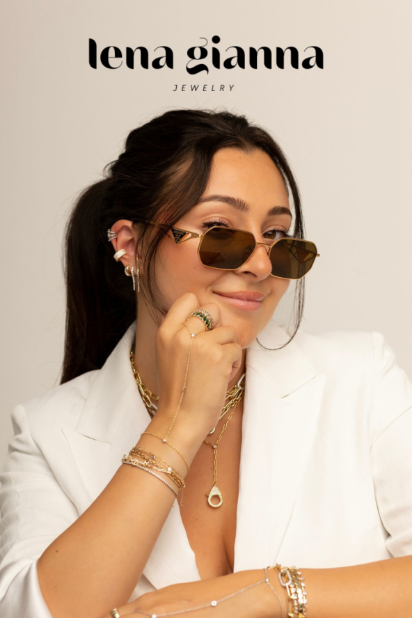 Woman in white blazer, wearing sunglasses and jewelry, smiles confidently. Text at the top reads “lena gianna jewelry.”