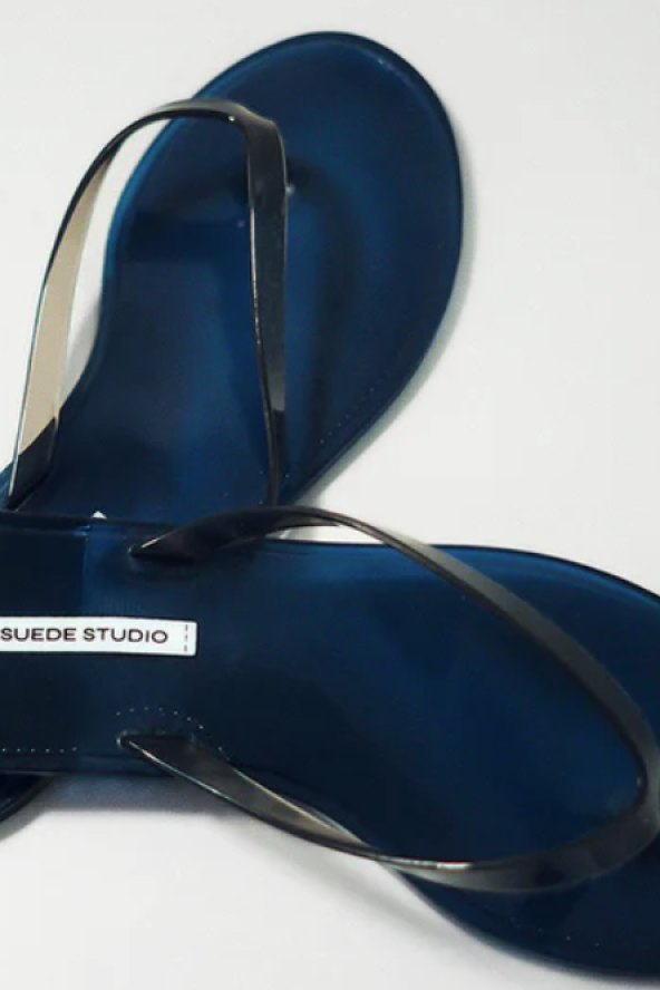Dark blue flip-flops with thin black straps, label reads "BLACK SUEDE STUDIO."