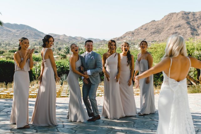 Groom and bridal party reacting as bride reveals first look on Paradise Views Patio.