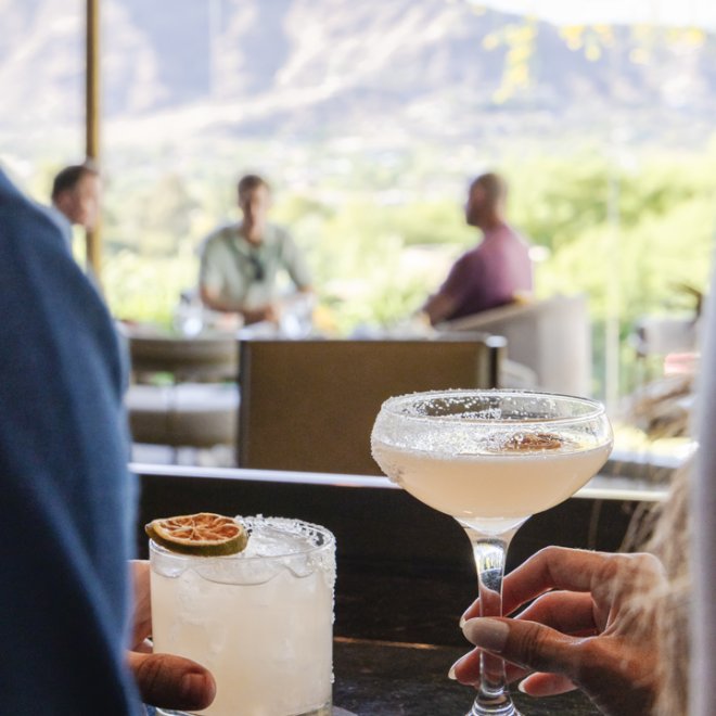 Couple enjoying cocktails in jade bar with beautiful scenic view.