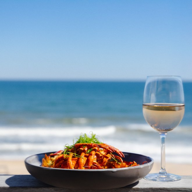 Lobster dish and rose on ledge facing beach