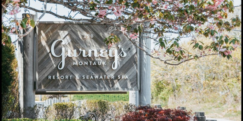 Gurney's Montauk sign surrounded by springtime blooms.