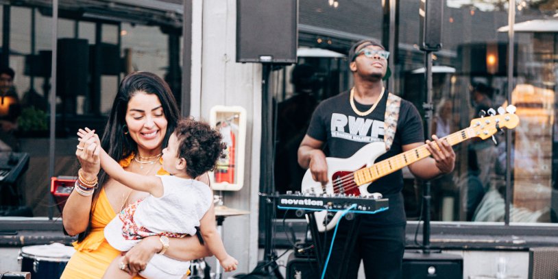 Woman dancing with small child to live music in Montauk.