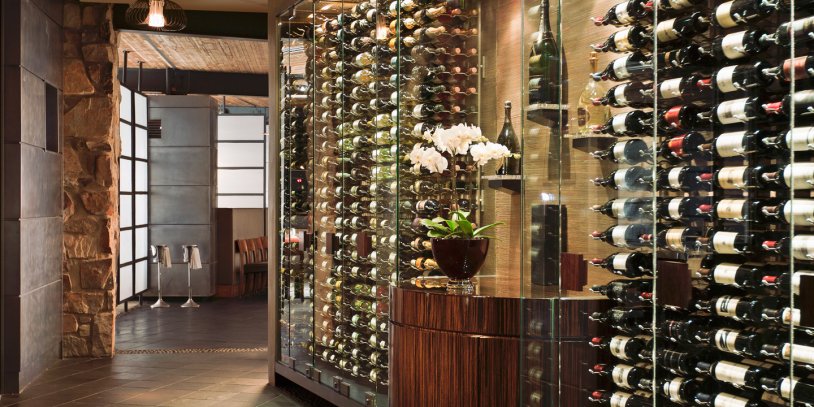 Elements wine wall with wine bottles and floral decor.