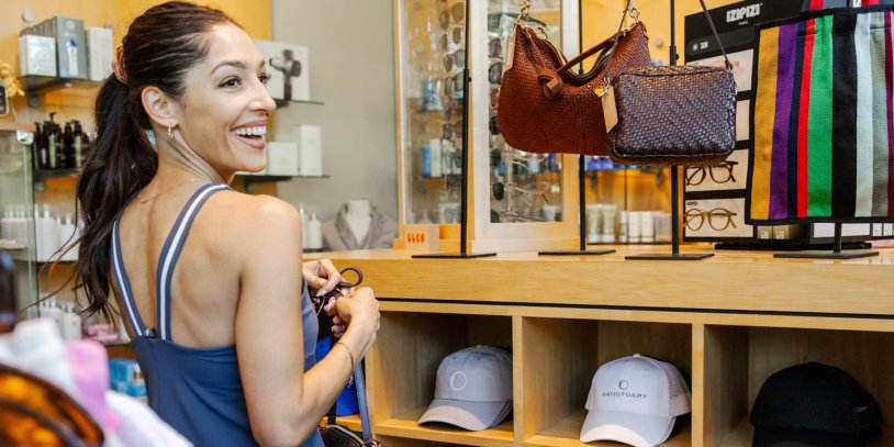 Woman smiling as she shops brand apparel at Sanctuary Spa's Boutique Shop.