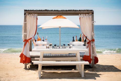 Beach Club cabana and picnic table with wine and champagne bottles.