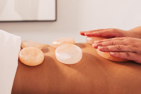 Woman receiving massage with white, smooth stones.