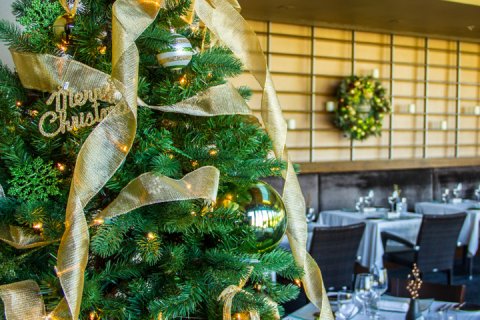 Close-up of Christmas Tree decorated with lights, bulbs and gold tensile in elements. 
