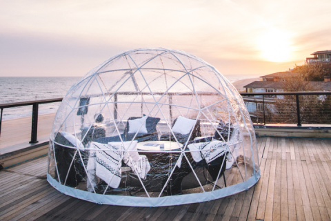A dining igloo overlooking the ocean at sunset at Gurney's Montauk Resort