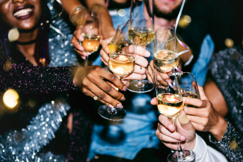 A group of friends brings their Champagne glasses together in a cheers