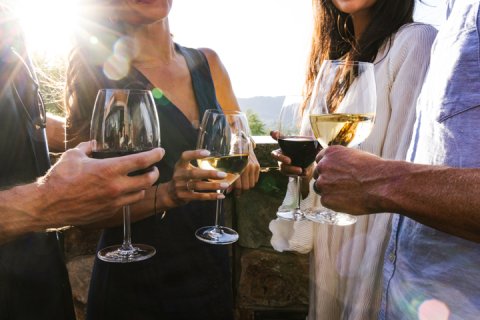 Two couples enjoying glasses of wine on elements Sunset Patio.