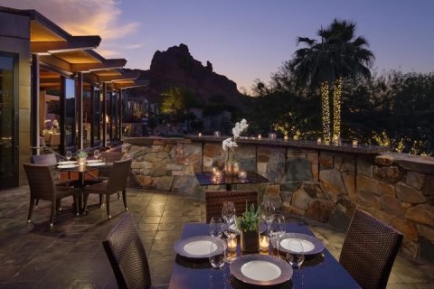 Elements sunset space outdoor dining deck with tables set for dinner and spectacular view of camelback mountain.