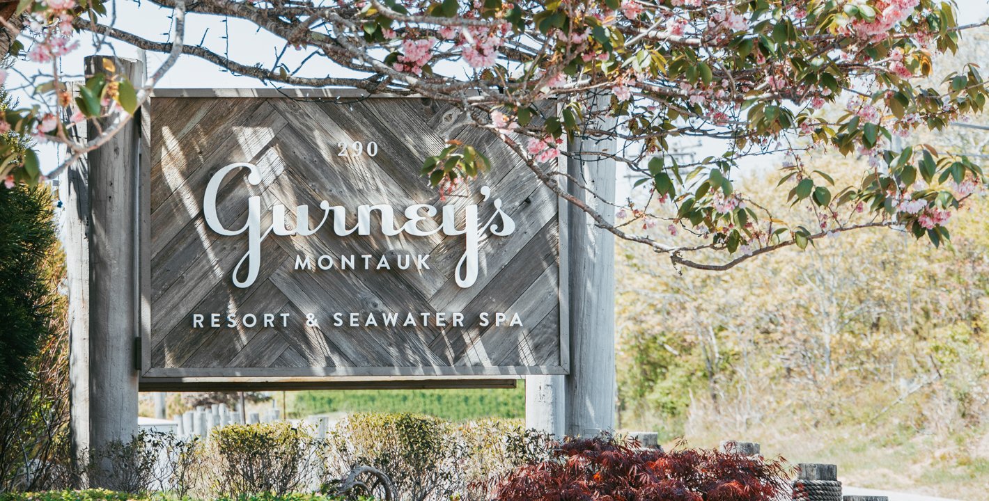 Gurney's Montauk sign surrounded by springtime blooms.