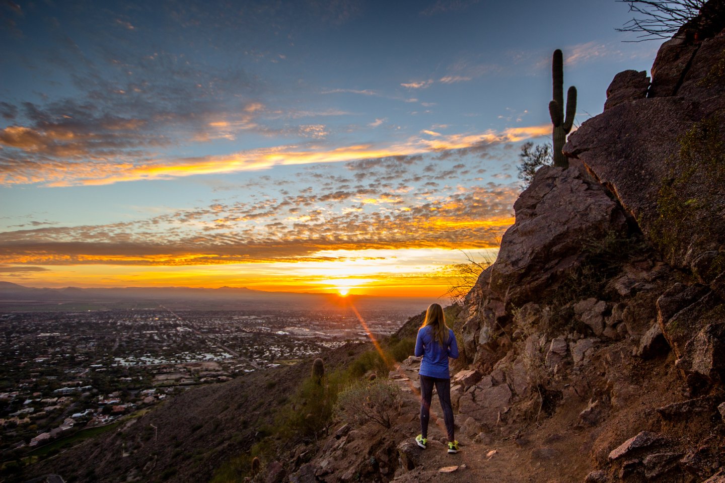 Woman watching sunset from Camelback Mountain.
