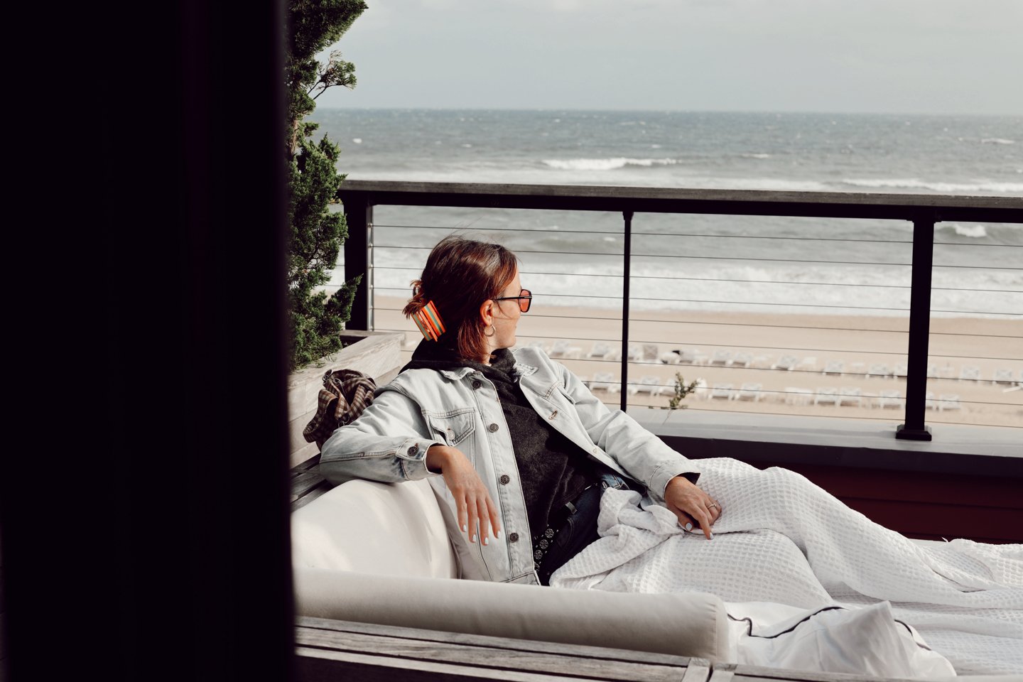 Woman watching the waves from her room's patio. 