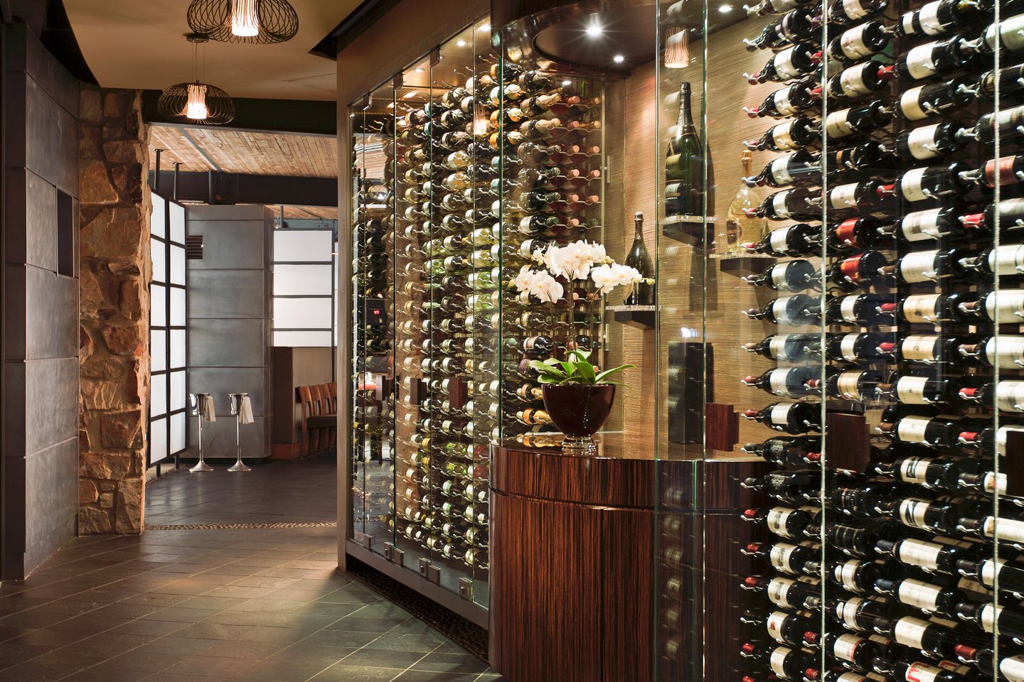 Elements wine wall with wine bottles and floral decor.