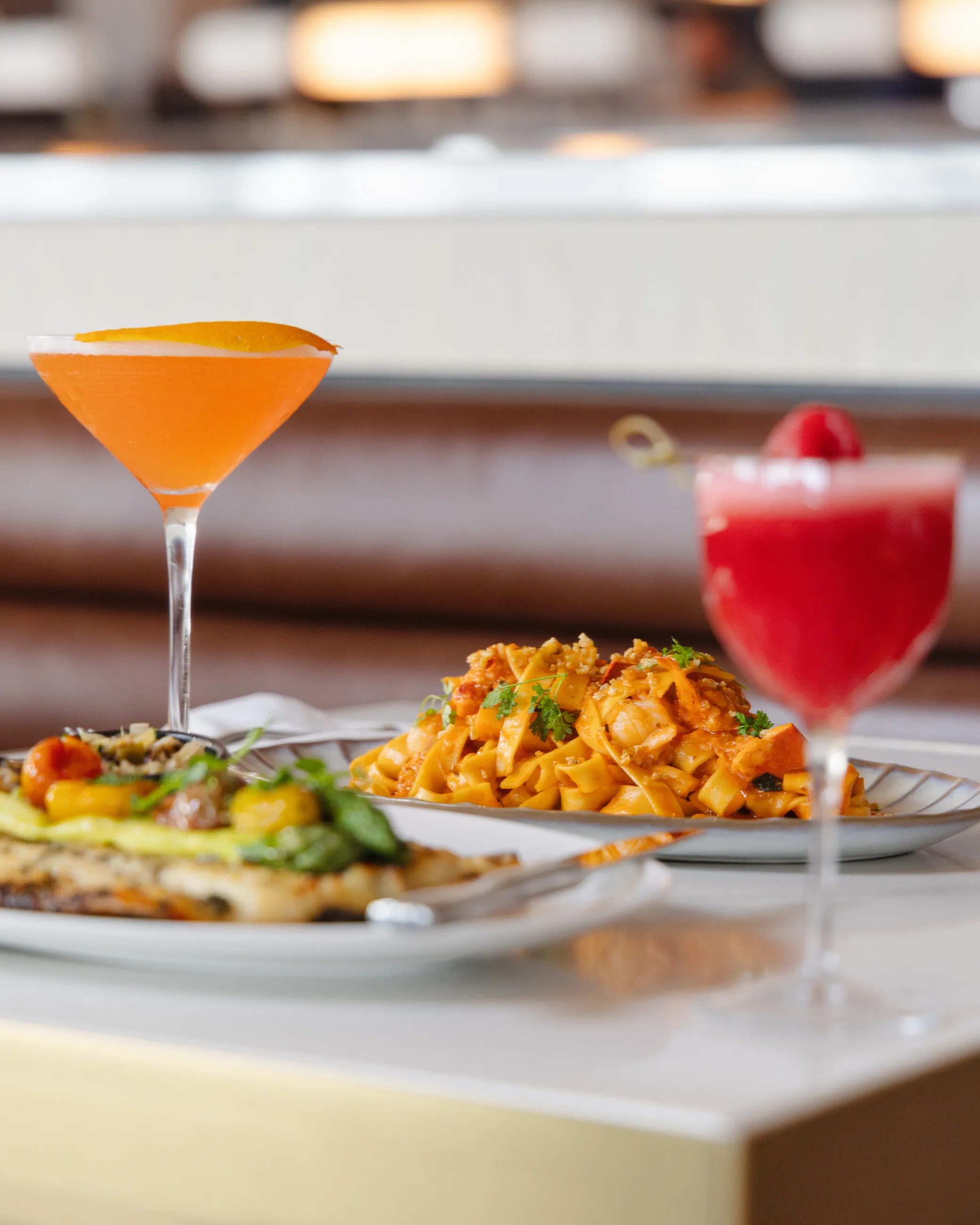 A table setting with two cocktails and two plates of food