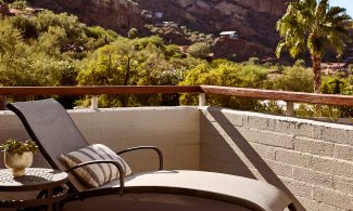 Outdoor patio with lounge chair and table.