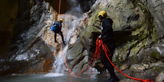 two men climbing rocks and waterfalls