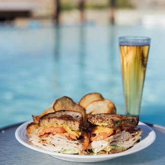 Sandwich, chips and beer poolside.