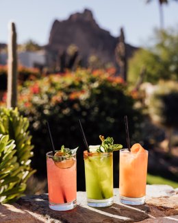 An assortment of summer cocktails with Praying Monk in background.