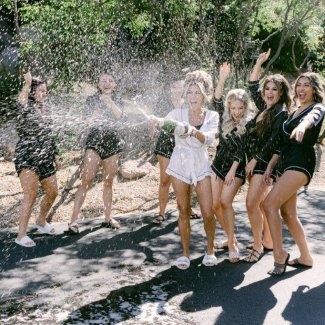 Bride and Bridesmaids spraying champagne and celebrating.