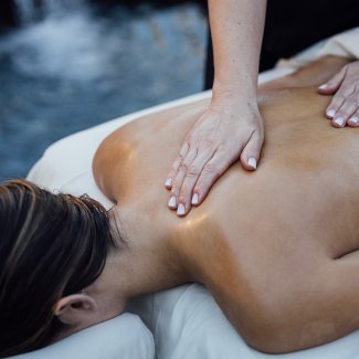 Woman getting massage by running water feature.