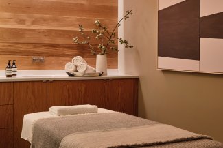 Spa treatment room with treatment table and wood finishes.