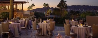 Paradise Views patio with tables and linens at dusk.