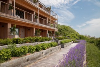 View of Gurney's Montauk wooden beach pathway in front of rooms with wooden finished patios.