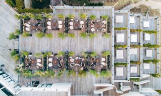  Bird’s eye view of outdoor, wood East Deck with fire pits and lounge chairs set up.