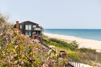 View of Montauk shoreline with beautiful foliage and Gurney's Montauk in distance.